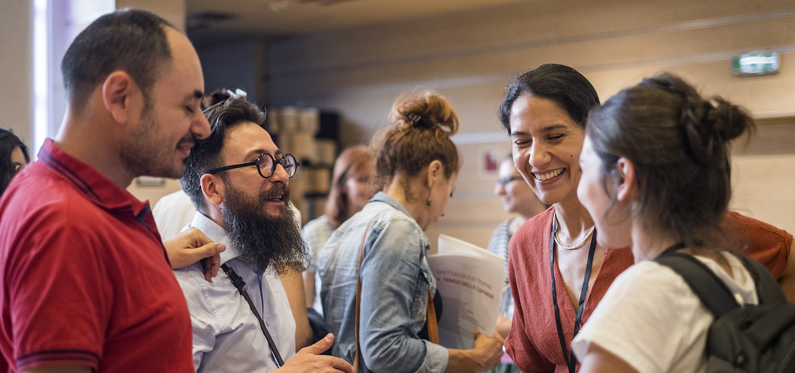 Due uomini e due donne che chiacchierano tra loro e sorridono. Foto di Elisa Vettori.