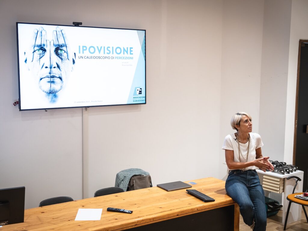 Foto scattata durante la formazione. Il docente, seduta sul bordo della cattedra, si rivolge al pubblico. Foto di Marta Cervone.